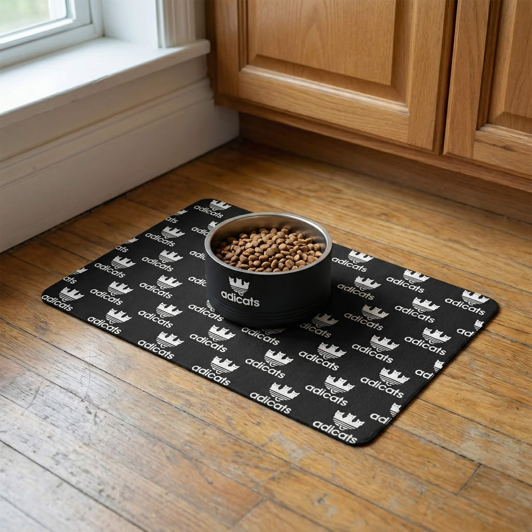 Adicats Logo Stainless Steel Cat Bowl in black, on the Adicats Repeat Logo Cat Feeding Mat