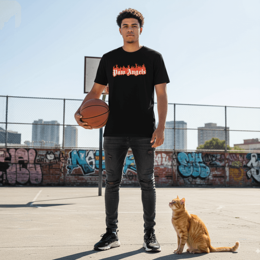 Young man wearing Paw Angels cat t shirt, designer parody brand streetwear, standing on basketball court with orange cat beside him