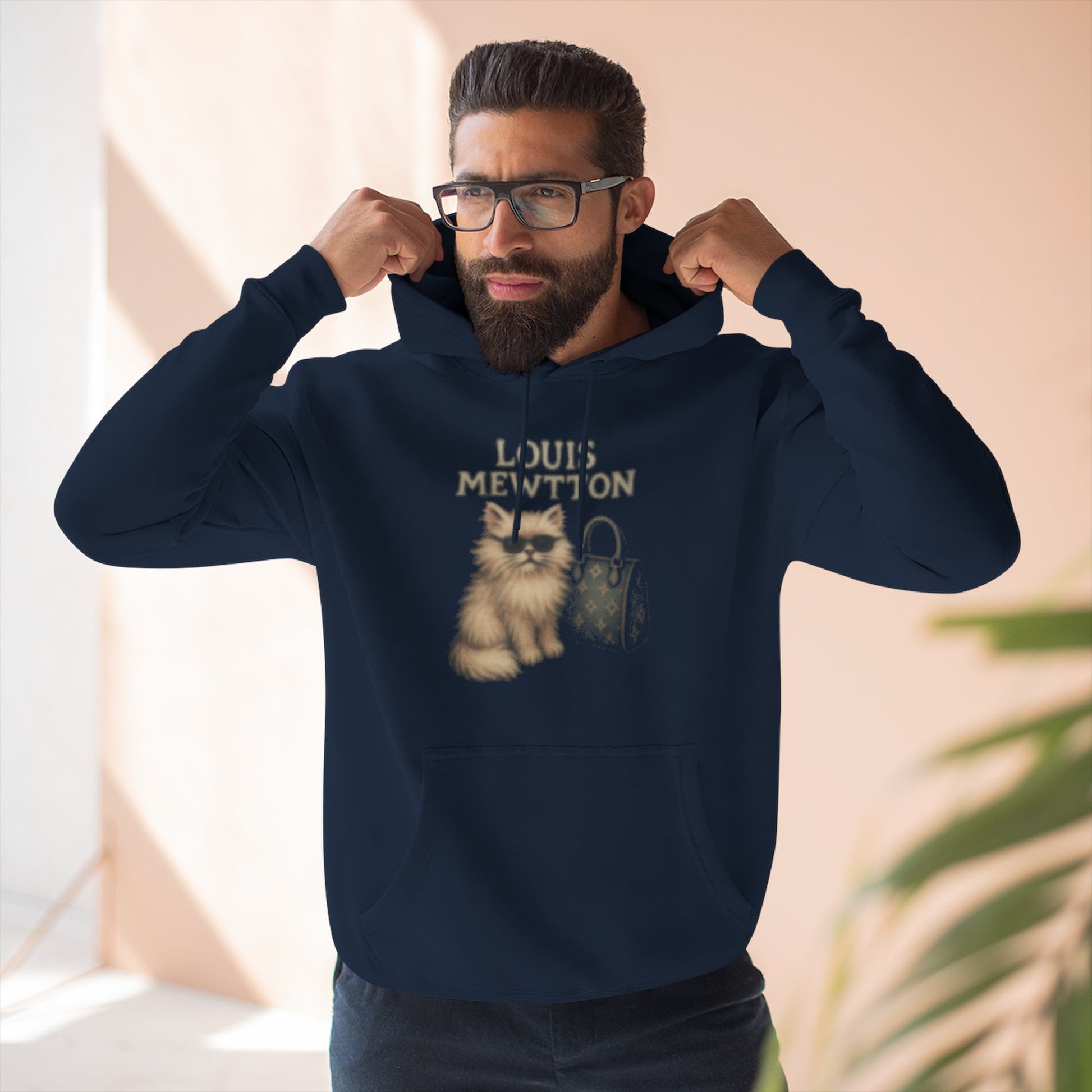 Man adjusting hood in Louis Mewtton navy cat graphic hoodie, designer parody hoodie for cat lovers
