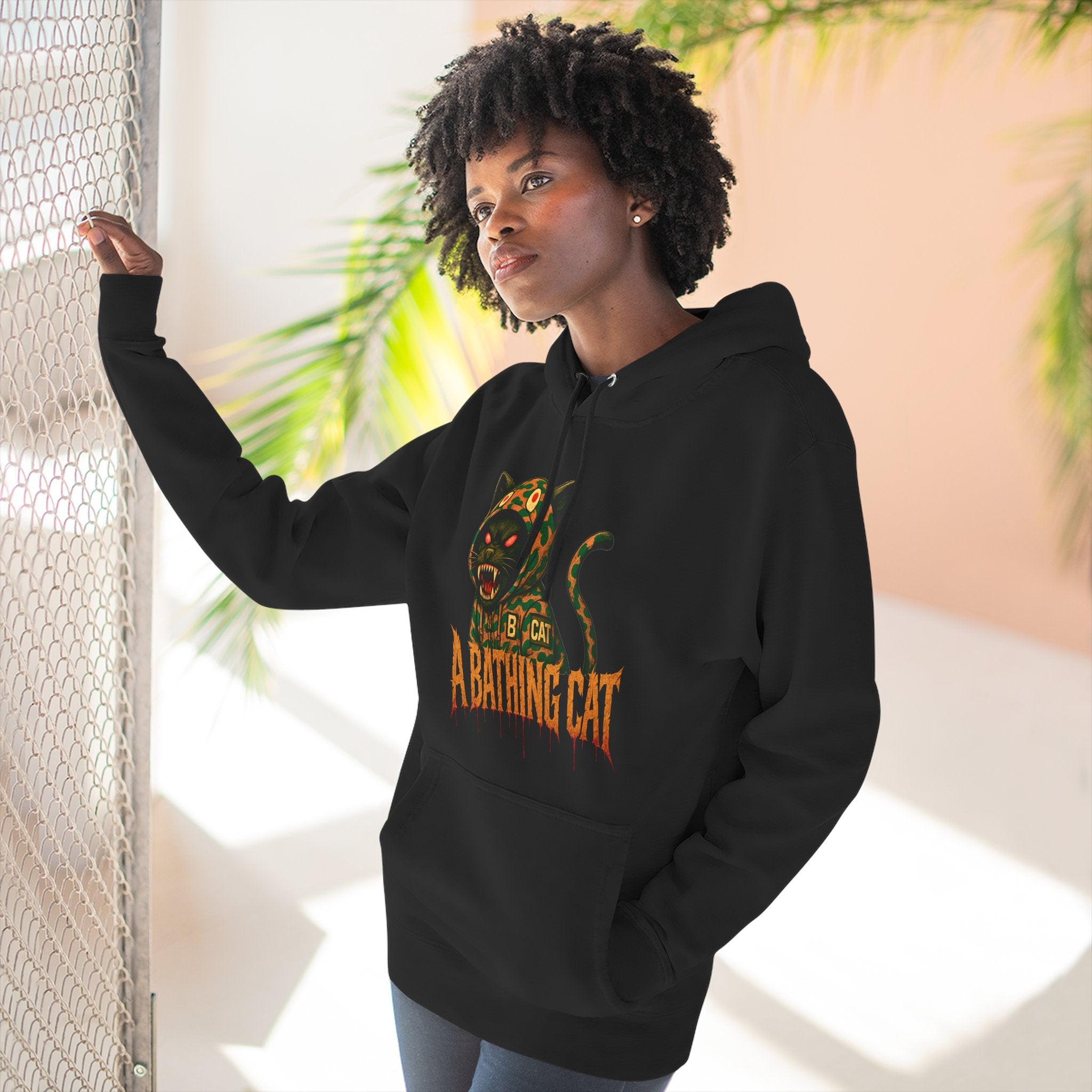 Model wearing black A Bathing Cat jungle predator hoodie indoors, cat themed apparel