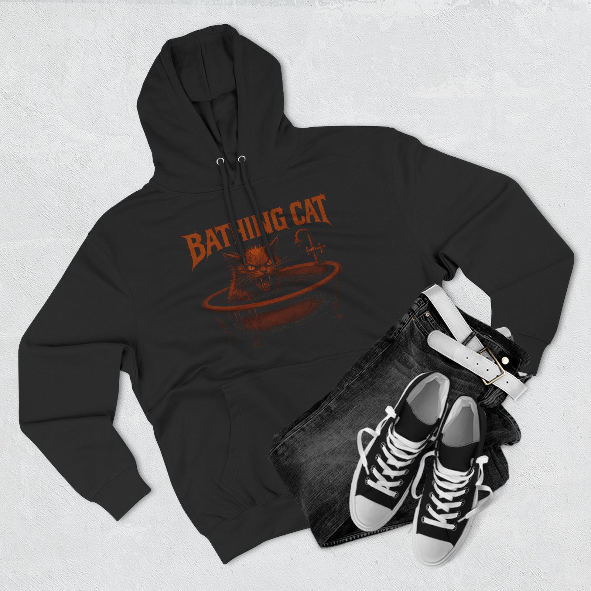 Flat lay of A Bathing Cat black hoodie with sneakers and jeans, stylish cat themed clothing