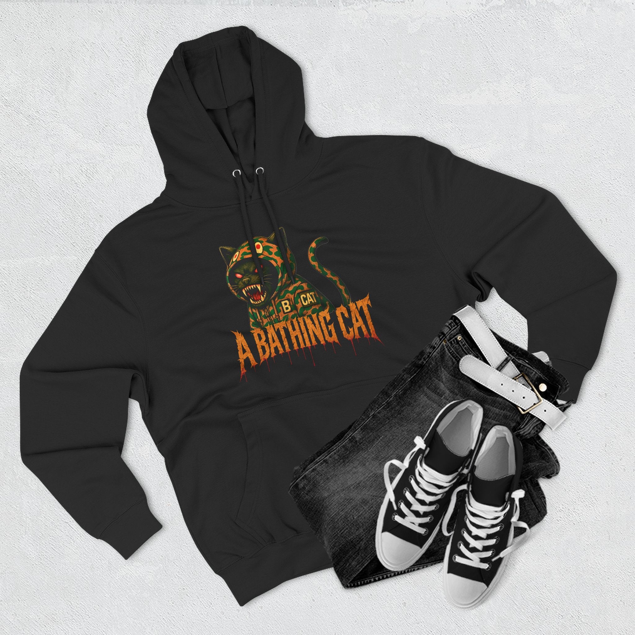 Flat lay of black A Bathing Cat jungle predator hoodie with sneakers, cat themed clothing