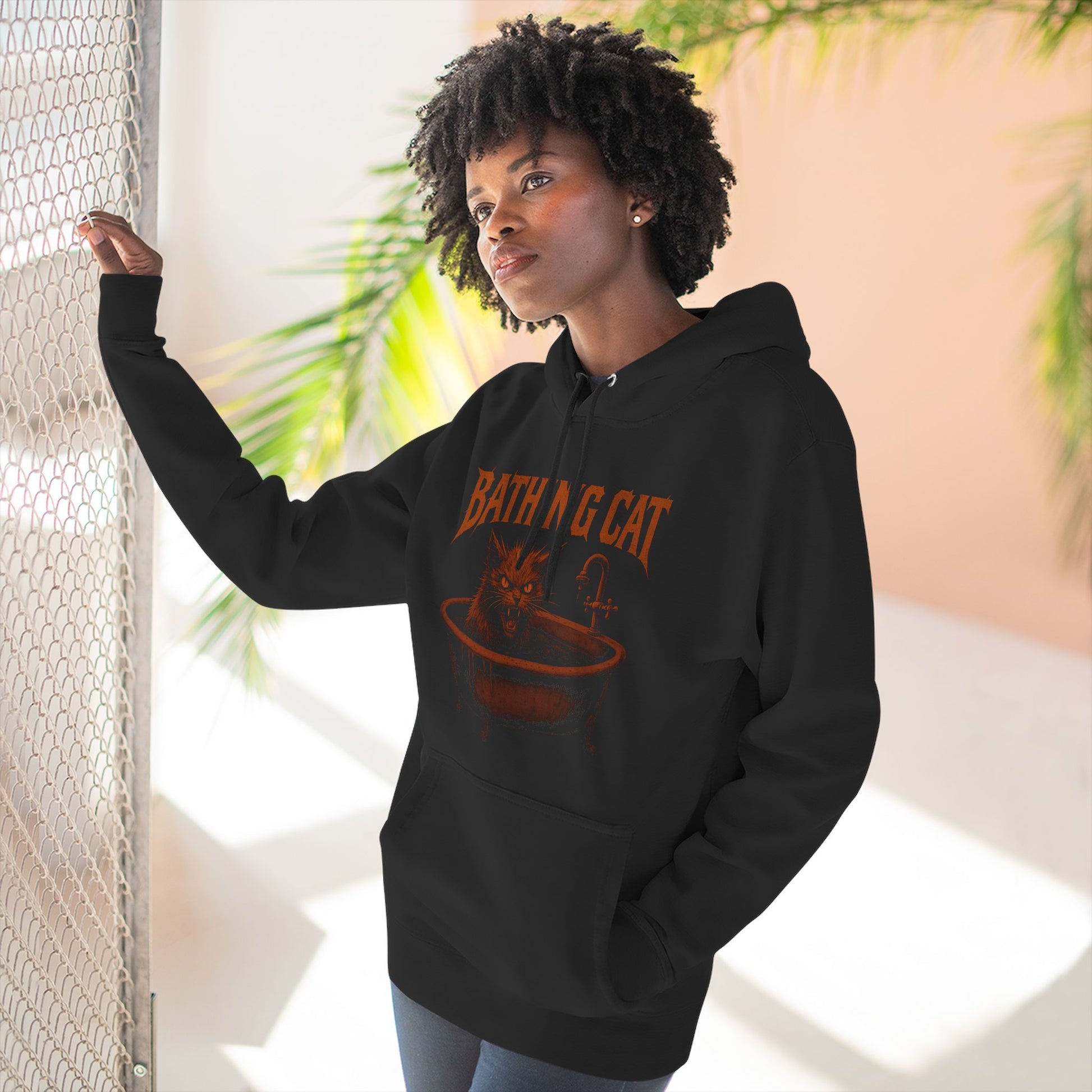 Model posing indoors wearing A Bathing Cat tub rage hoodie, cat themed apparel