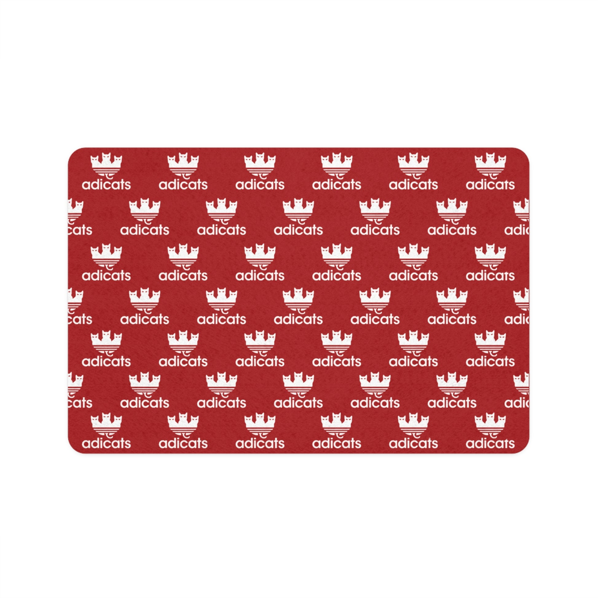 cat feeding red mat with white 'adicats' logo pattern on a white background
