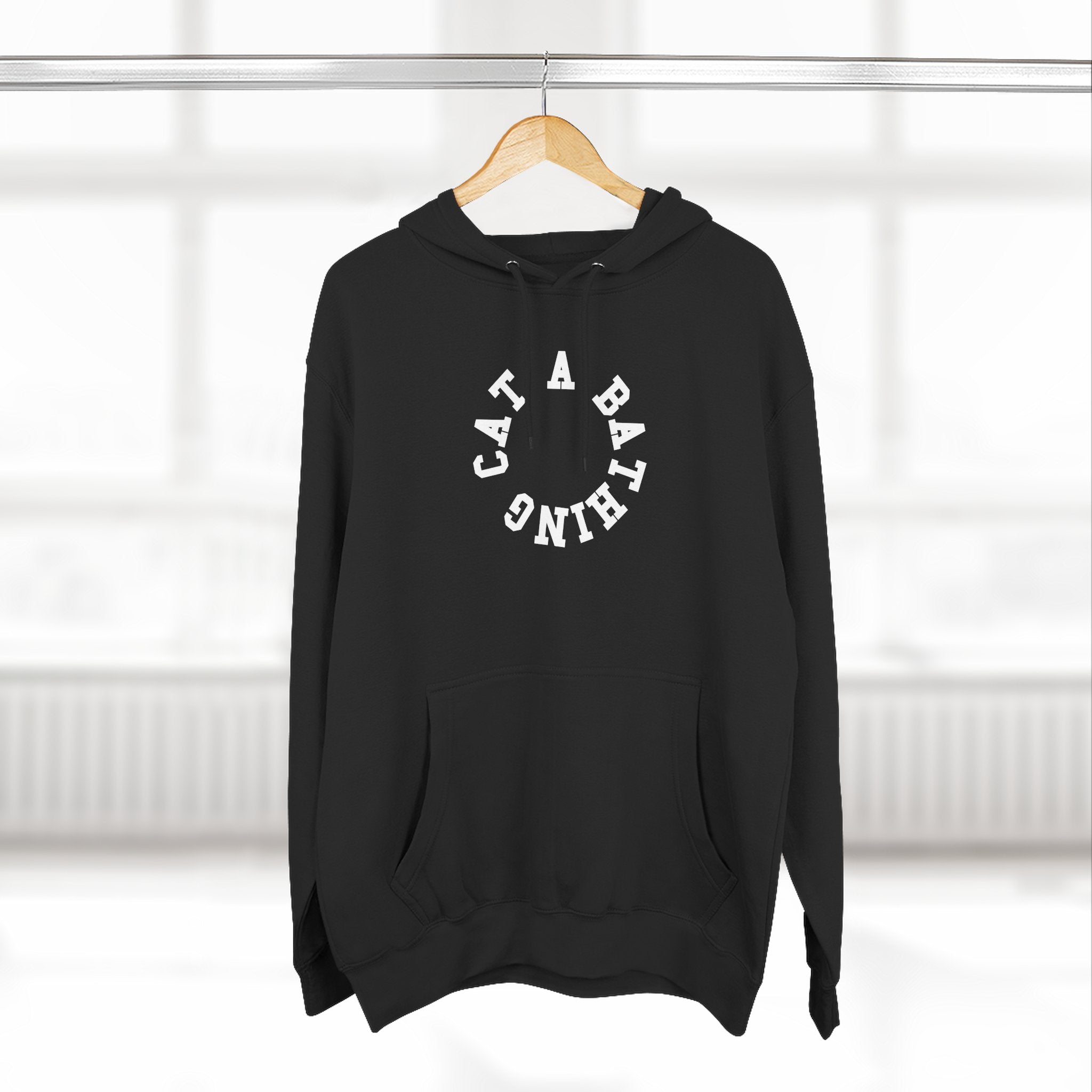 A Bathing Cat Circle Chest Logo Back Cat Graphic Print Black Hoodie, on a hanger