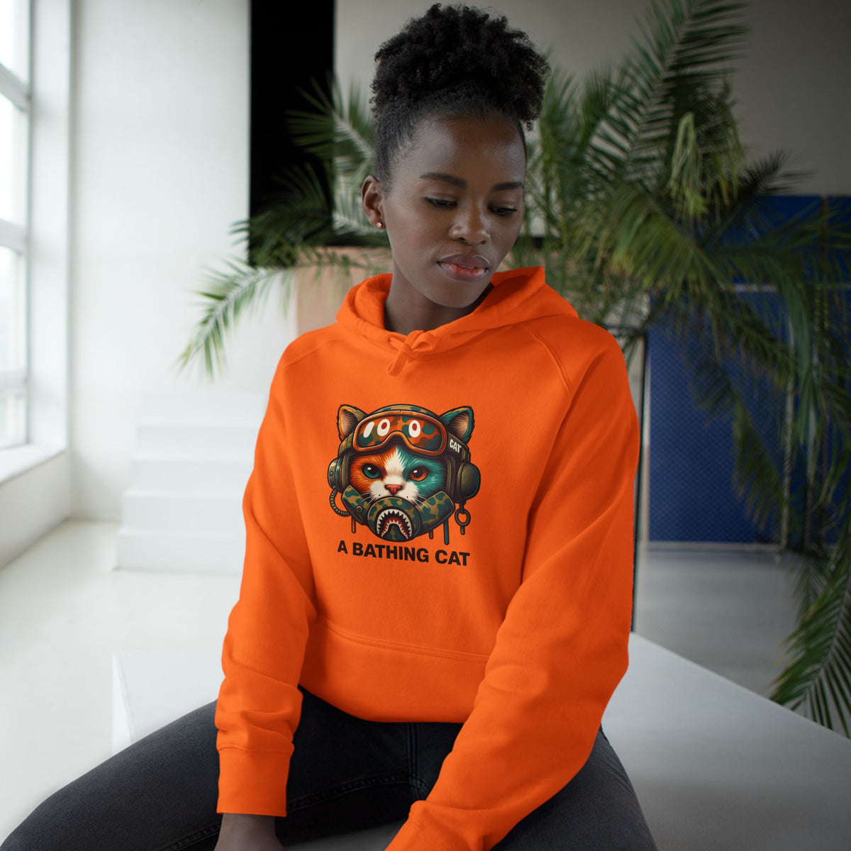 A Bathing Cat Tactical Pilot Graphic Hoodie in orange, worn by a female model