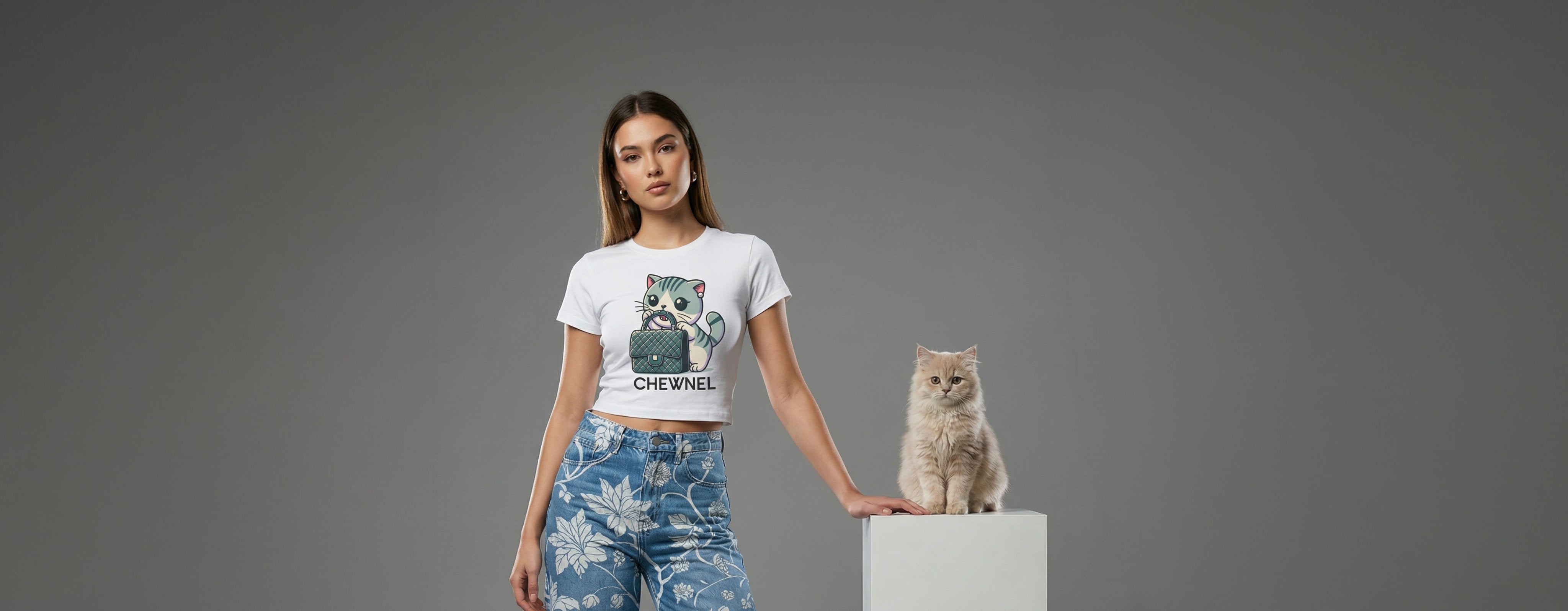 woman wearing a white cat themed baby tee for women with Chewnel graphic print, standing next to a fluffy white cat, main collection image