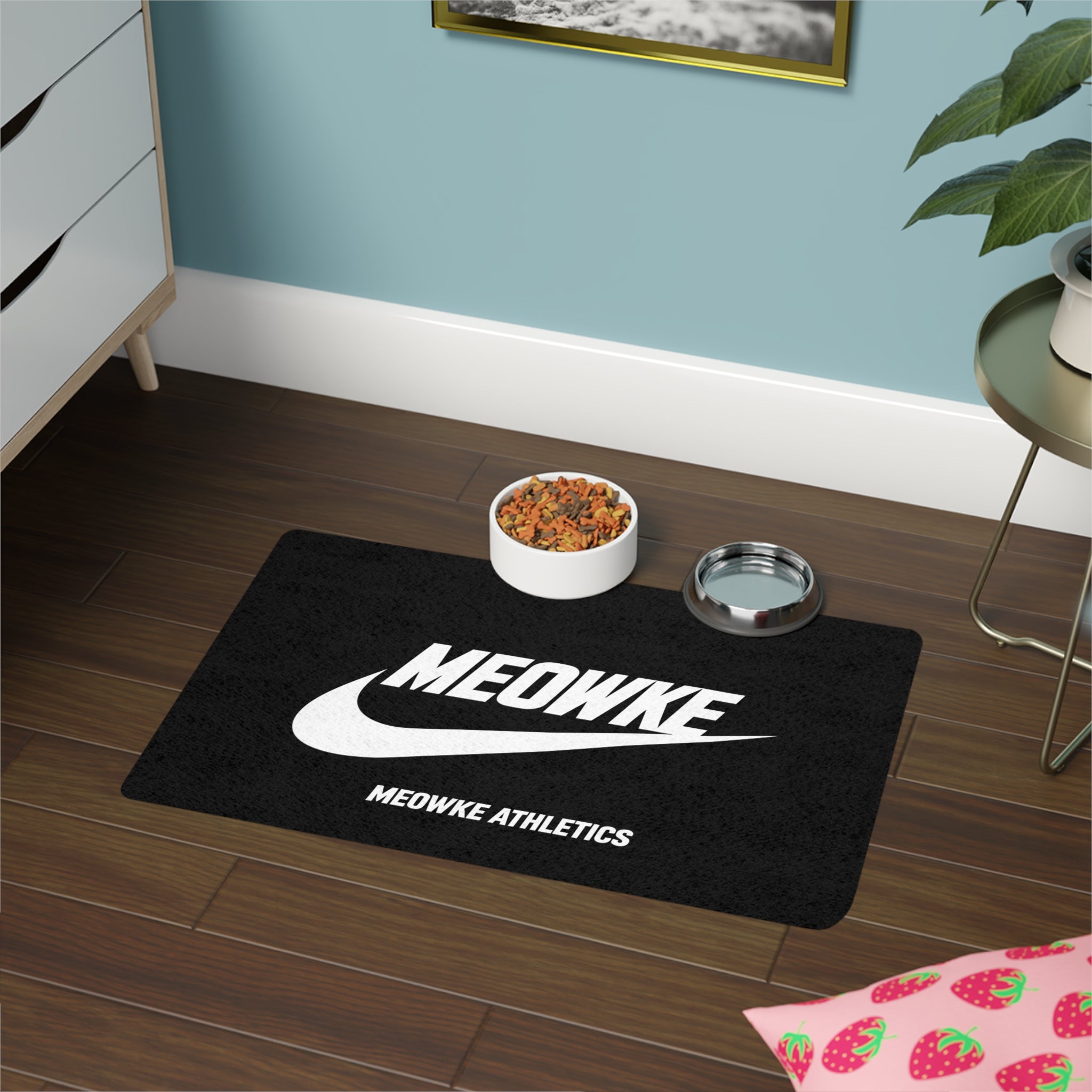 Meowke cat food mat in black with food and water bowls on an athletic logo layout
