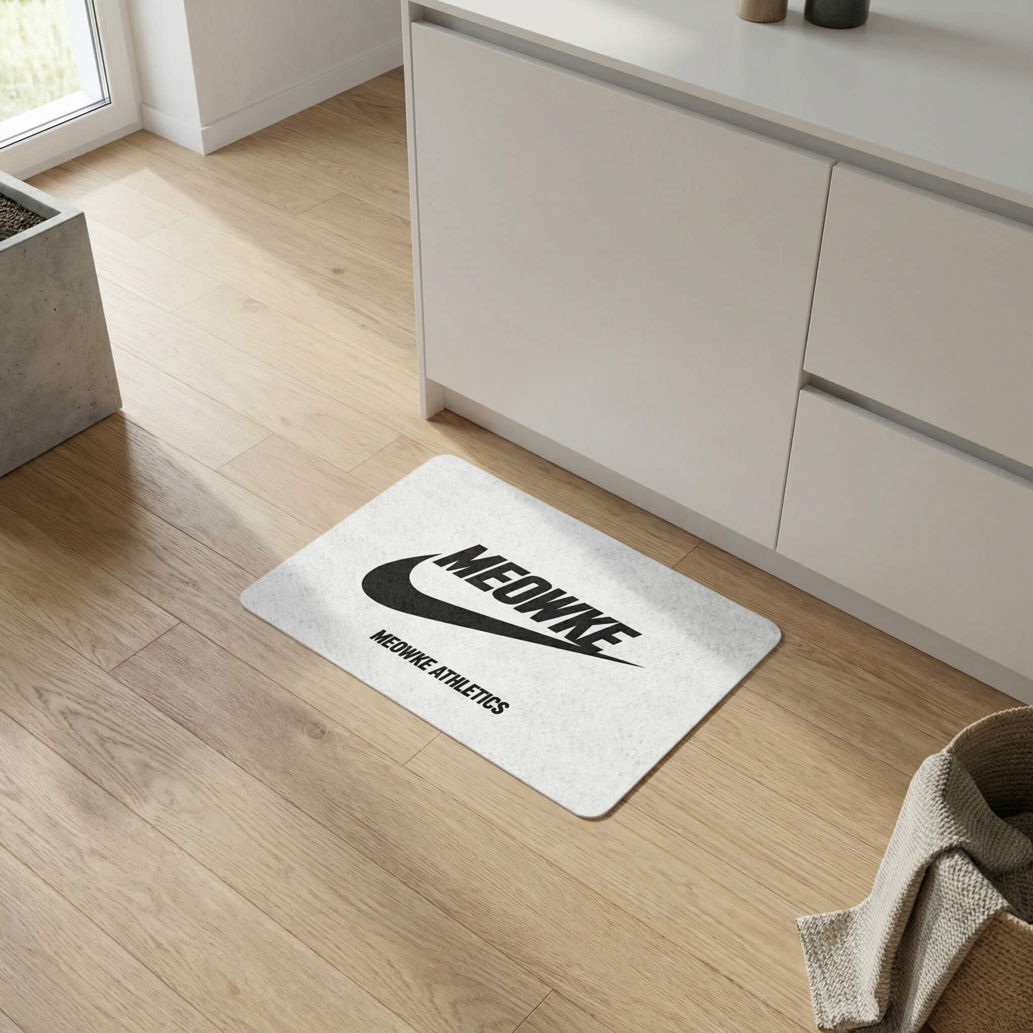 Meowke Athletics pet food mat in white on a light wood floor by Mad Cat Cartel