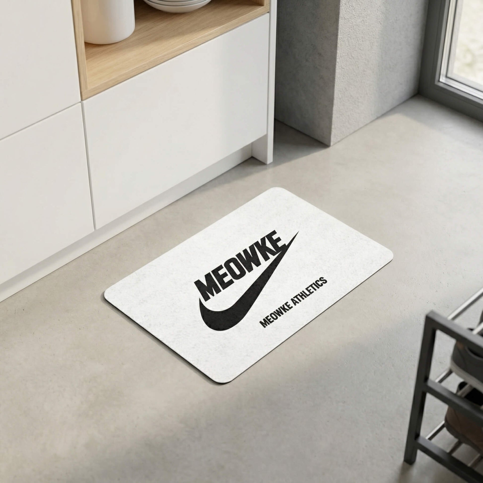 White cat feeding mat with Meowke logo near kitchen cabinets