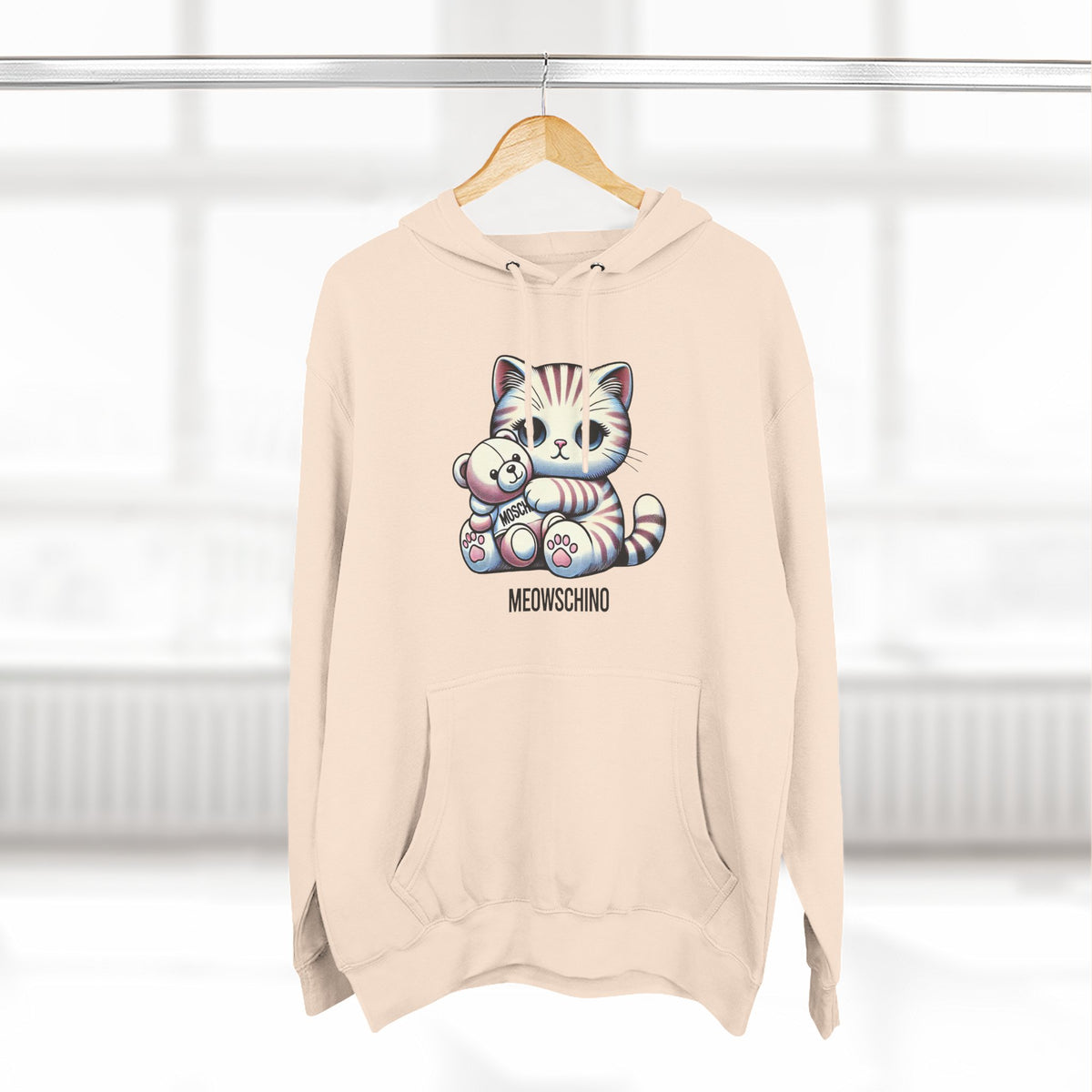 Meowschino Teddy Hug Cat Graphic Hoodie in pale pink, on a hanger