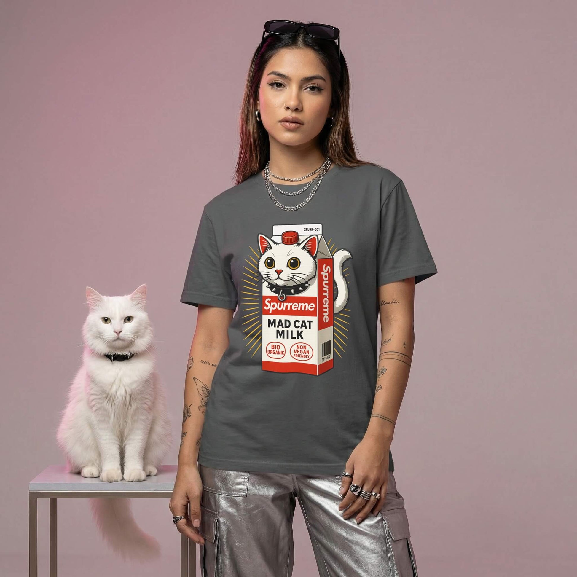 woman wearing a t-shirt with a cat milk carton design, standing next to a white cat on a pink background