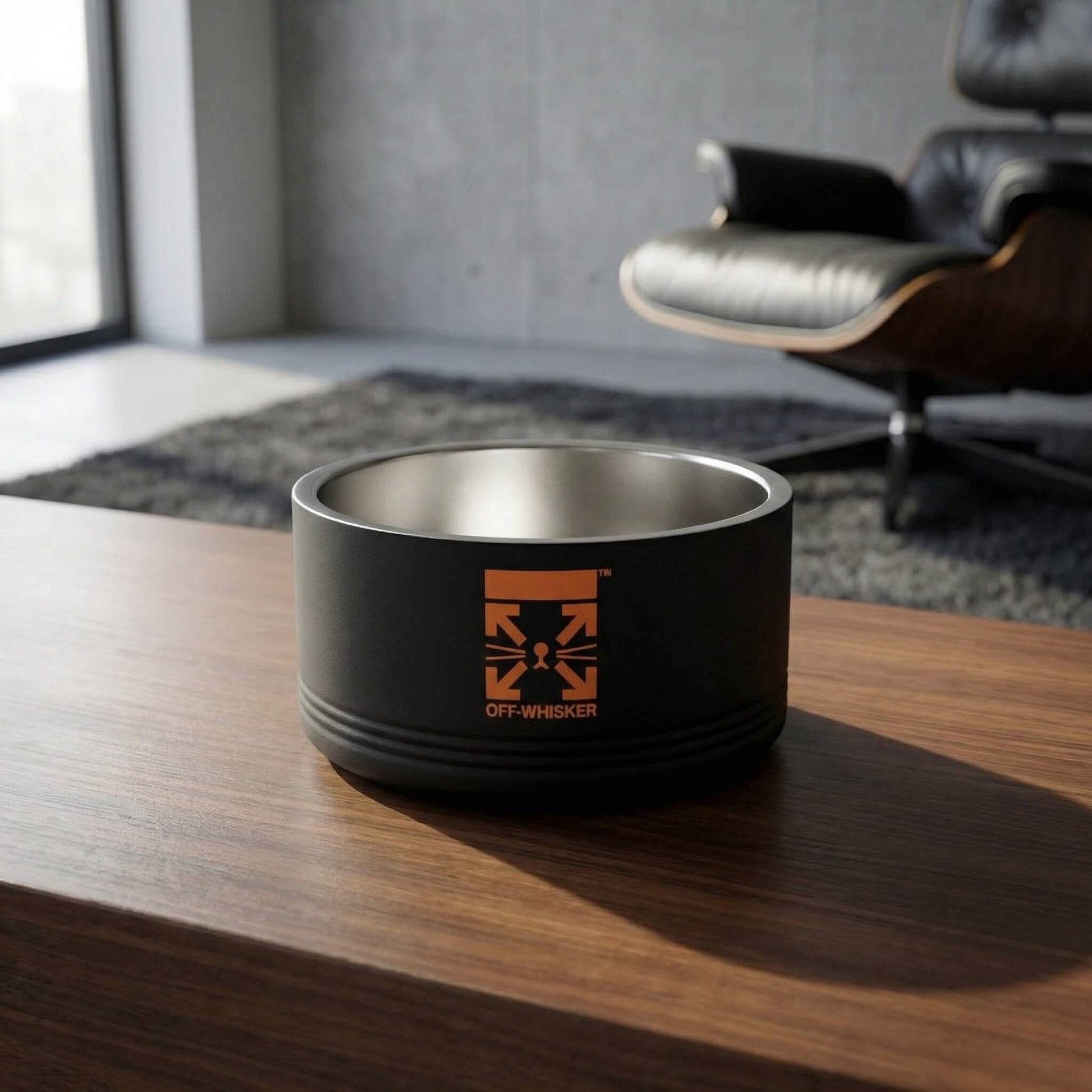 Black stainless steel designer cat bowl front logo on wood table