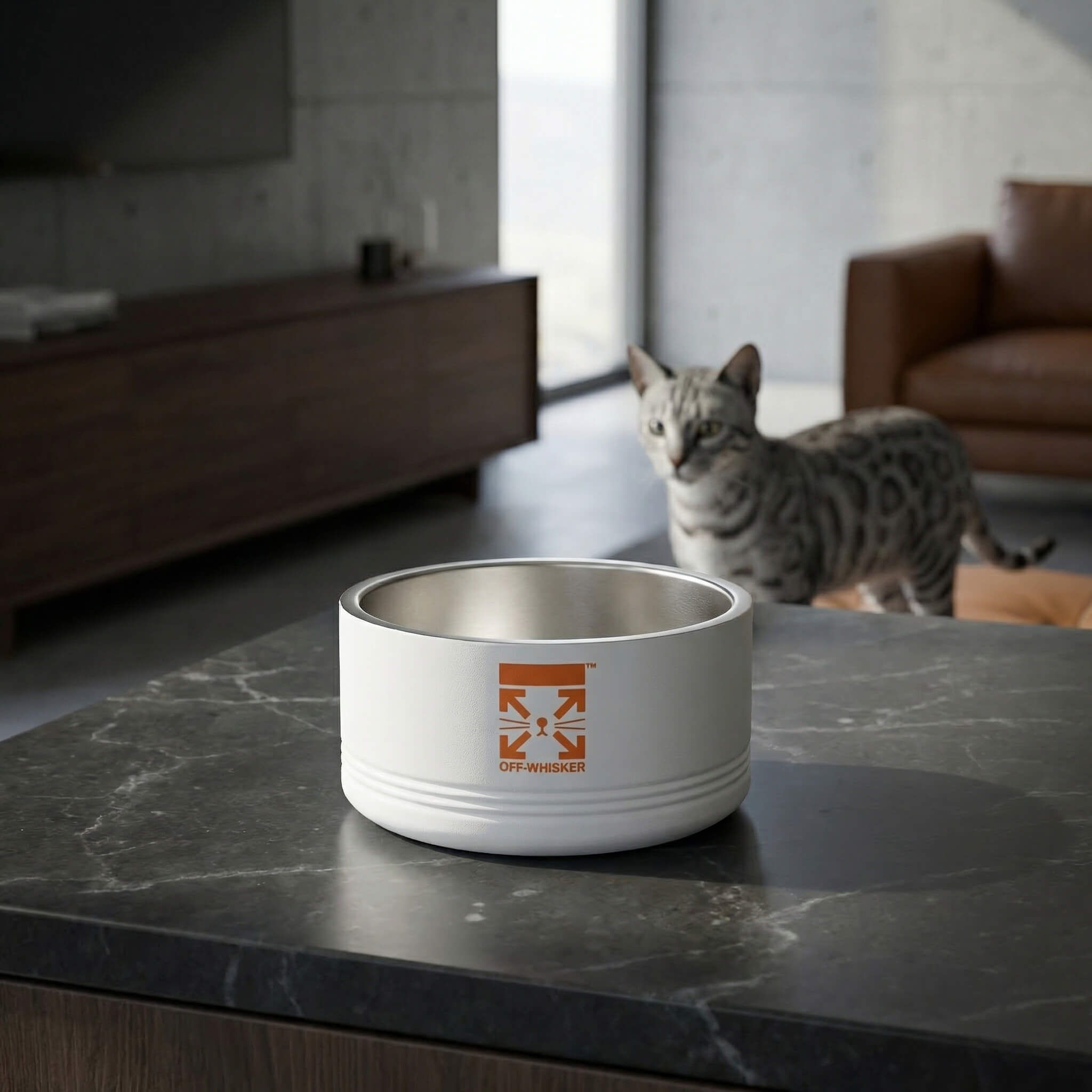 White cat bowl with a designer logo on a marble surface, with a cat in the background