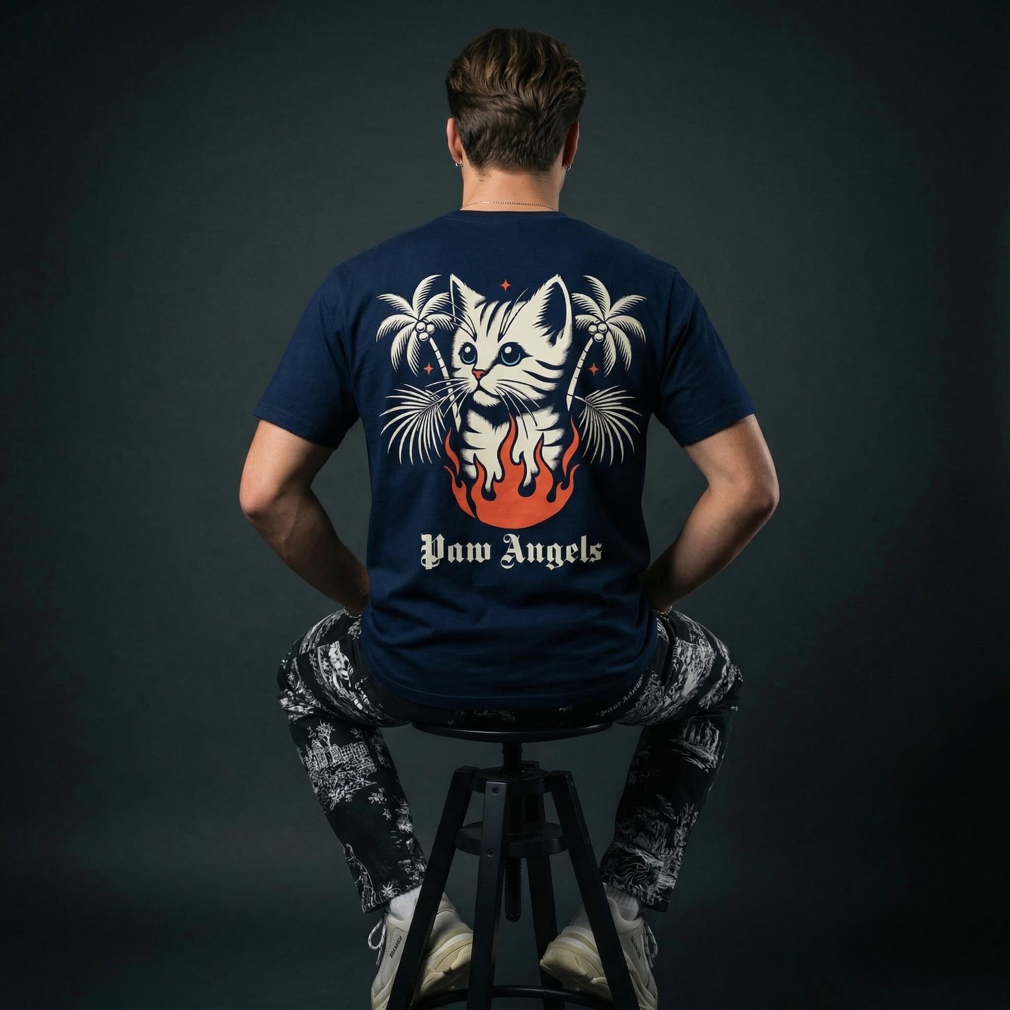 Paw Angels cat graphic t shirt by Mad Cat Cartel in navy with large back print worn by man model on stool