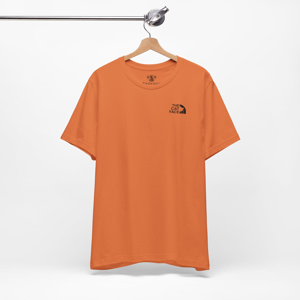 The Cat Face Classic Mini Chest Logo T-Shirt in burnt orange, on a hanger