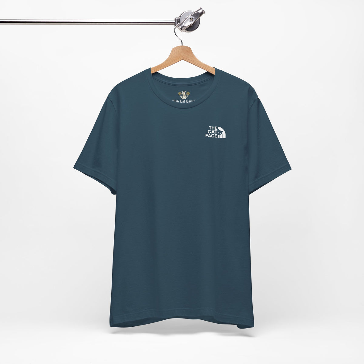 The Cat Face Classic Mini Chest Logo T-Shirt in deep teal, on a hanger
