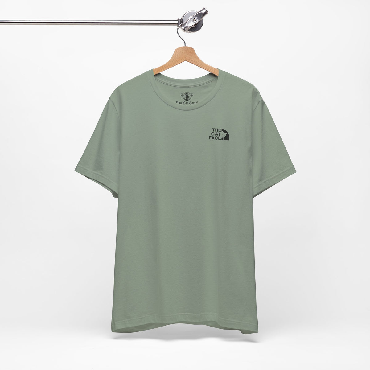 The Cat Face Classic Mini Chest Logo T-Shirt in sage, on a hanger