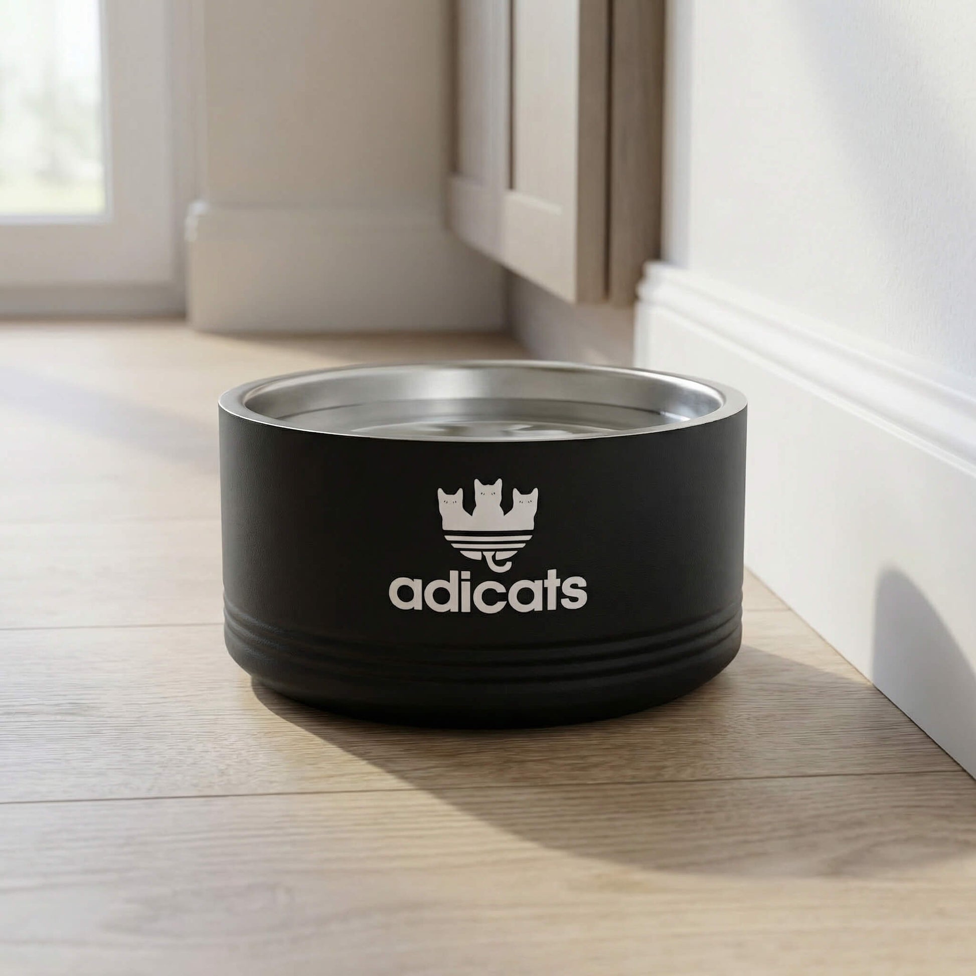 Black cat bowl with Adicats logo on a wooden floor