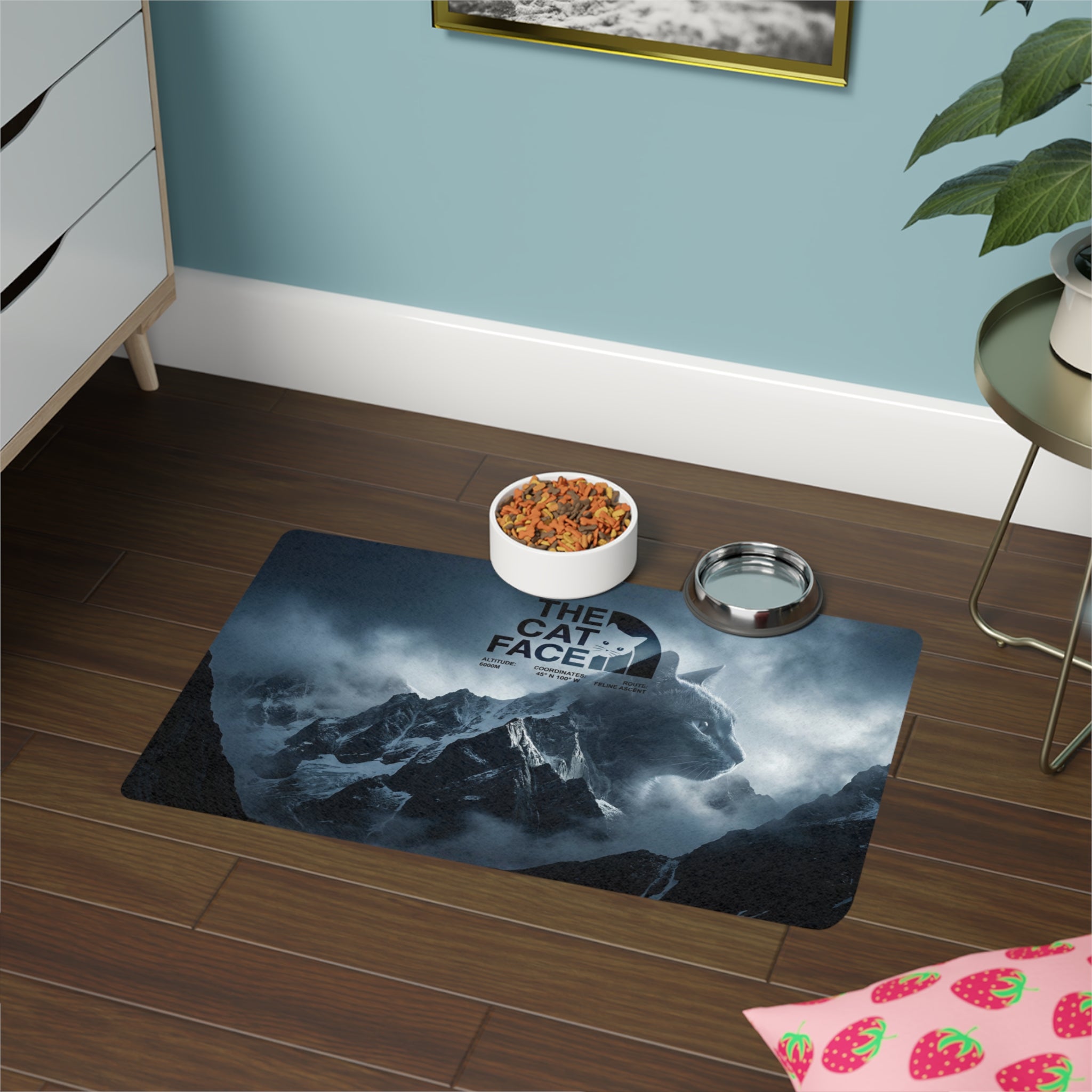 The Cat Face Expedition pet feeding mat with food and water bowls by Mad Cat Cartel