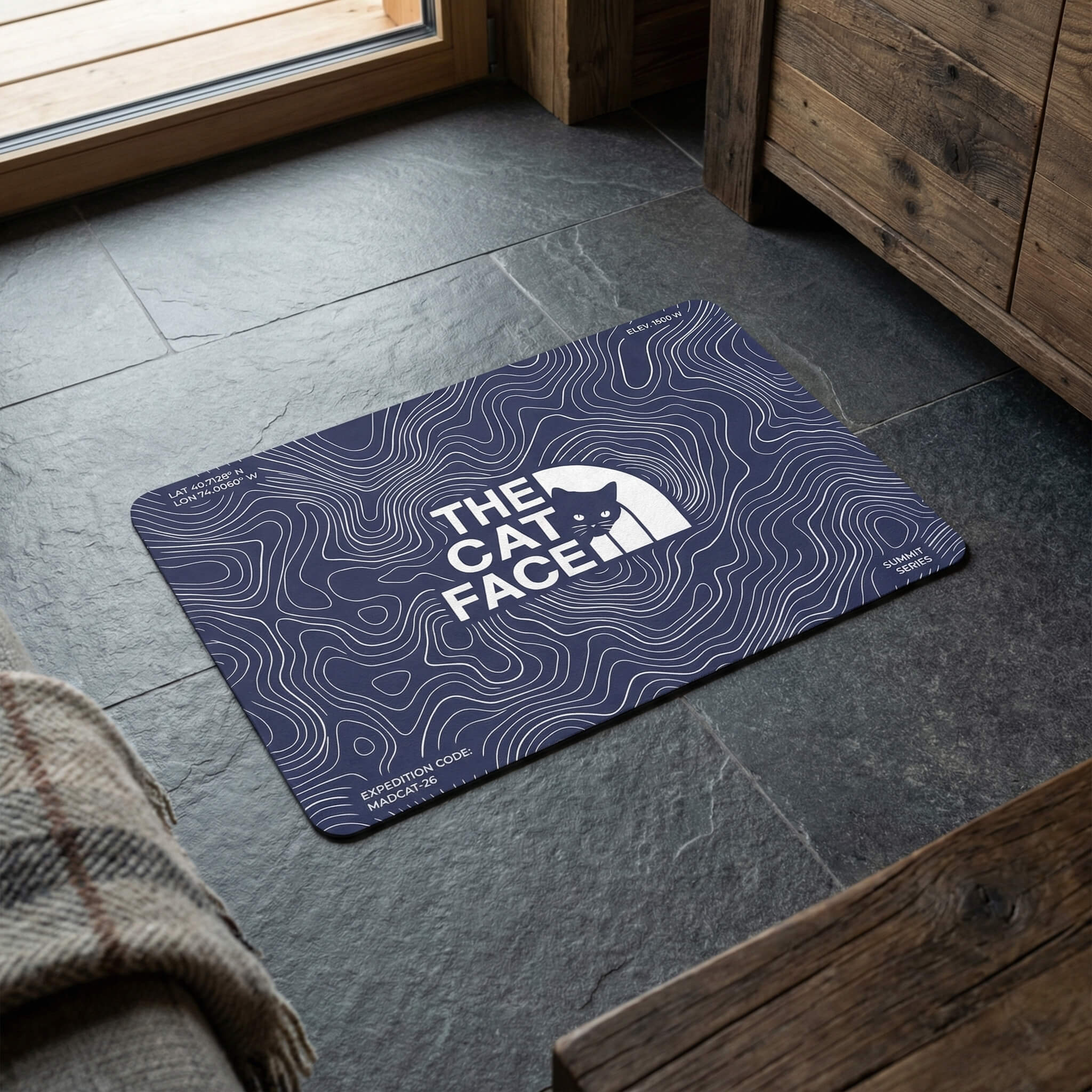 The Cat Face Summit Terrain Designer Cat Feeding Mat in blue, in a home setting