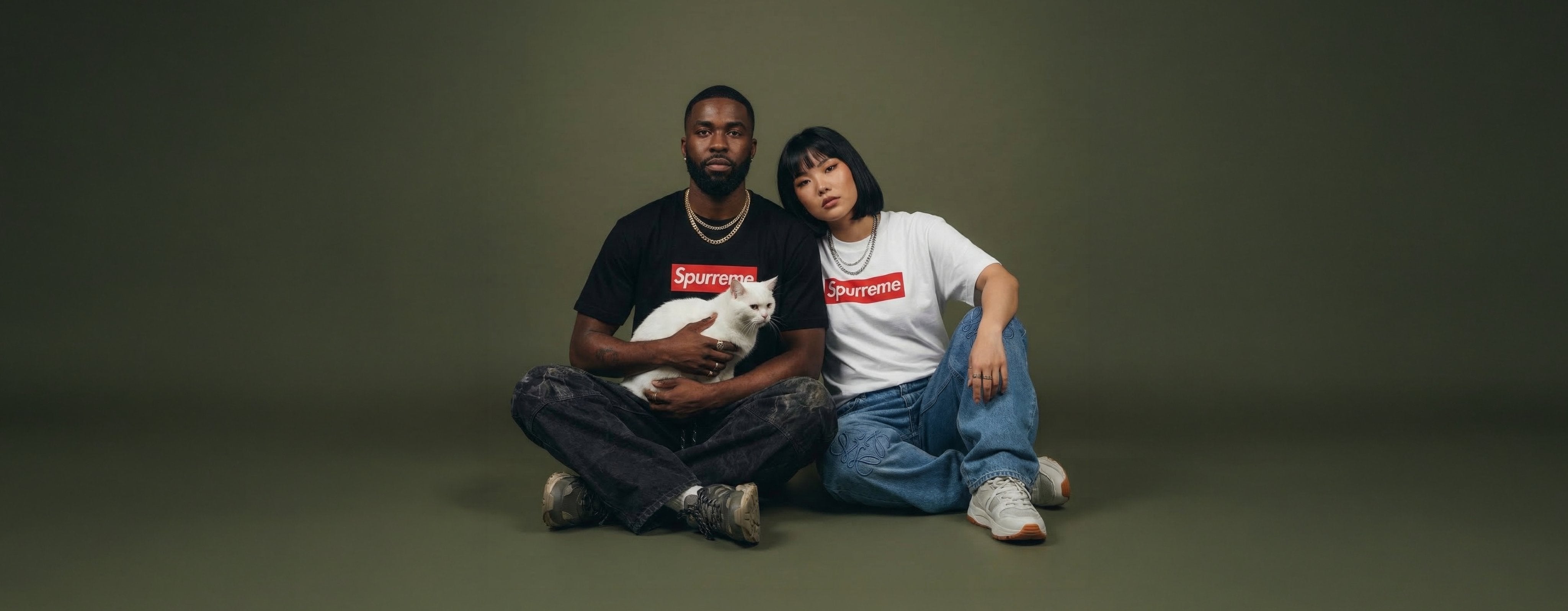 man and woman wearing unisex cat t shirts with graphic Spurreme prints and a white cat, collection banner image for funny graphic cat tees